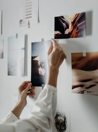 a designer trying to solve design problems by gluing his mood board on the wall