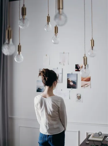 a young lady taking inspiration from pictures on the wall